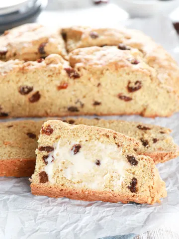 Slices of Irish Soda Bread with the loaf in the background. Recipe from A Kitchen Addiction